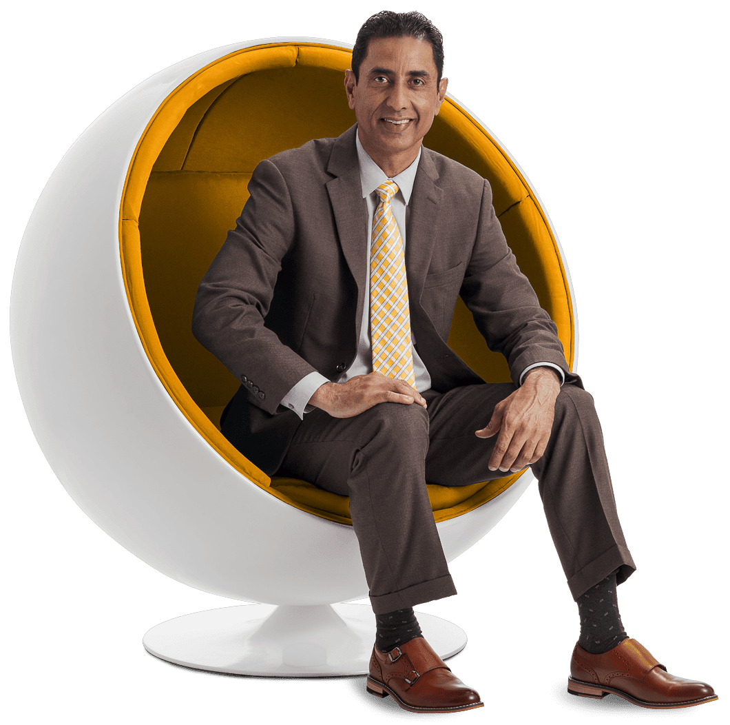 A man in a suit and tie sitting on an egg chair.