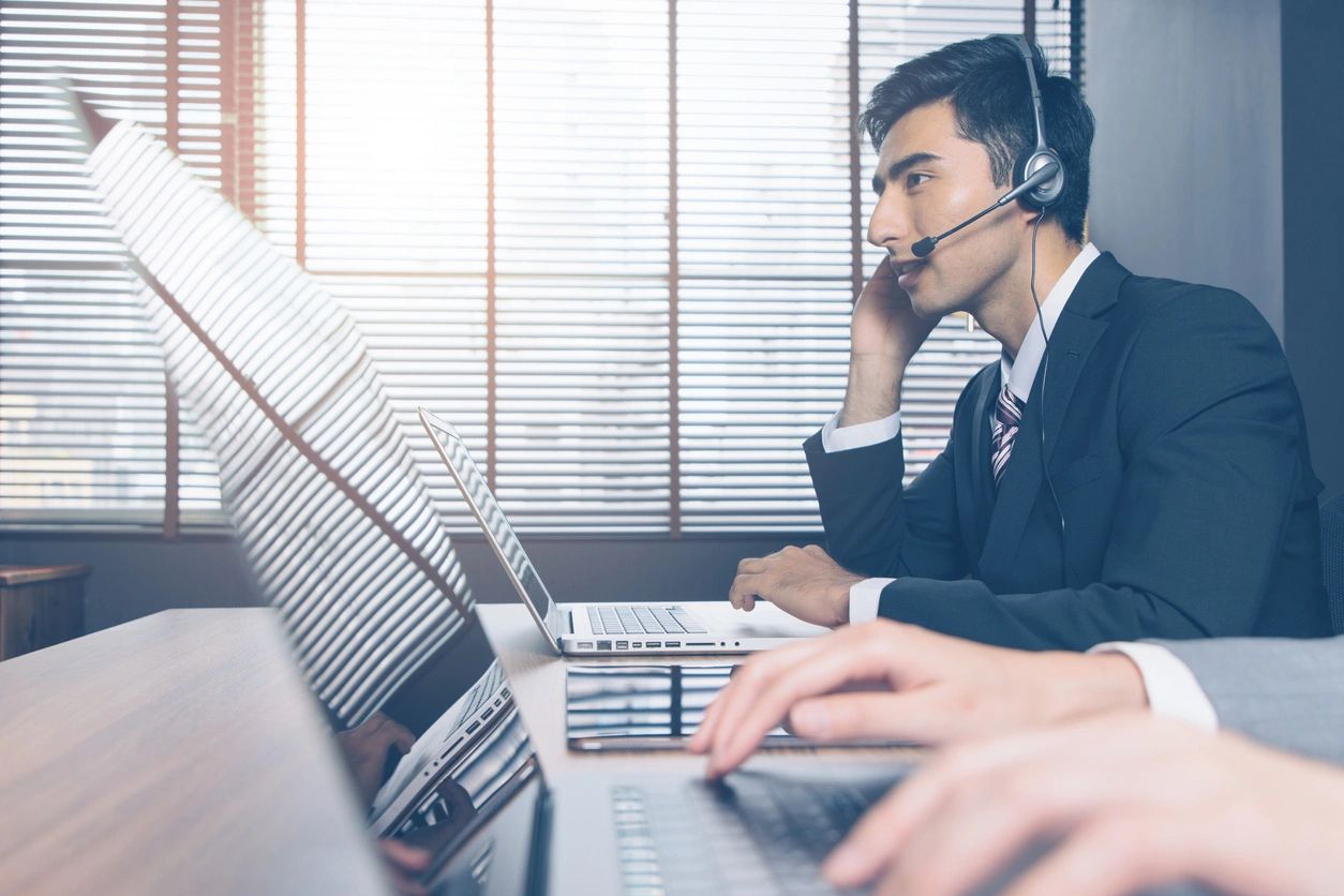 A man with headphones on sitting at a desk.