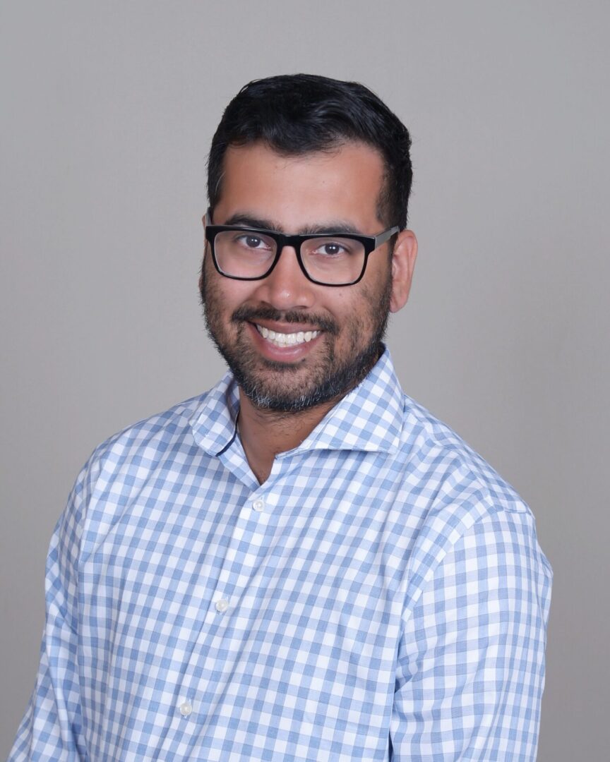 A man with glasses and a blue shirt