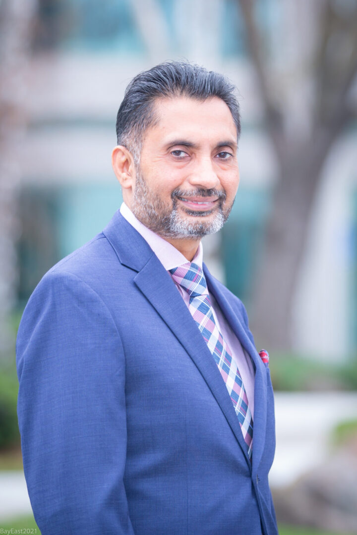 A man in a suit and tie standing outside.