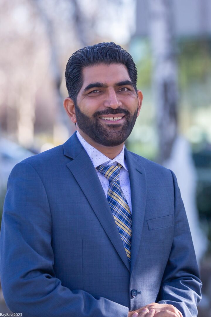 A man in a suit and tie smiling for the camera.