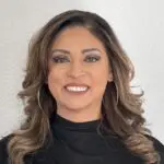 photo (db007c3b-9110-4a67-b64f-d5068ba30a74) Smiling woman with curly hair and earrings.